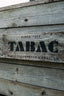 Logo Tabac auf Holzbalken